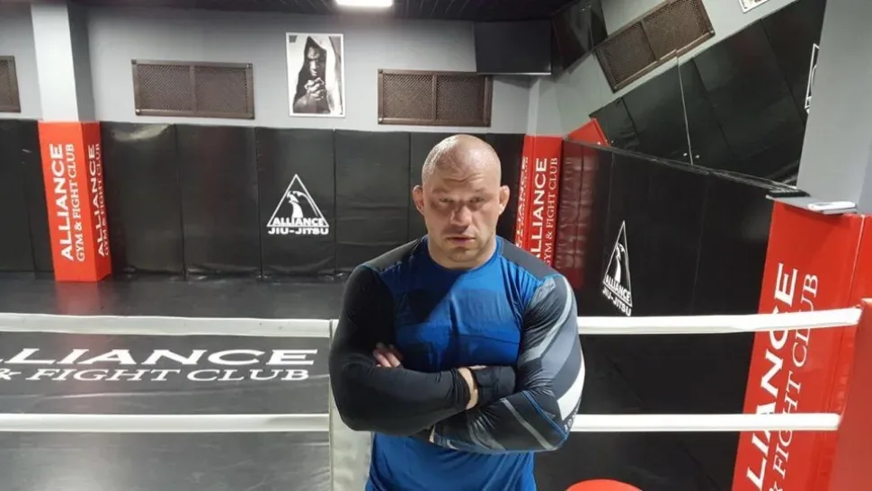 Спортсмен стоит, прислонившись к стене, интервью о карьере и подготовке