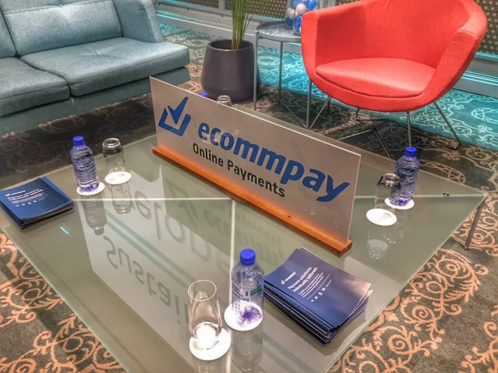 Лаунж-зона форума с фирменным стикером ecommpay на стеклянном столе Лаунж-зона форума с фирменным стикером ecommpay на стеклянном столе