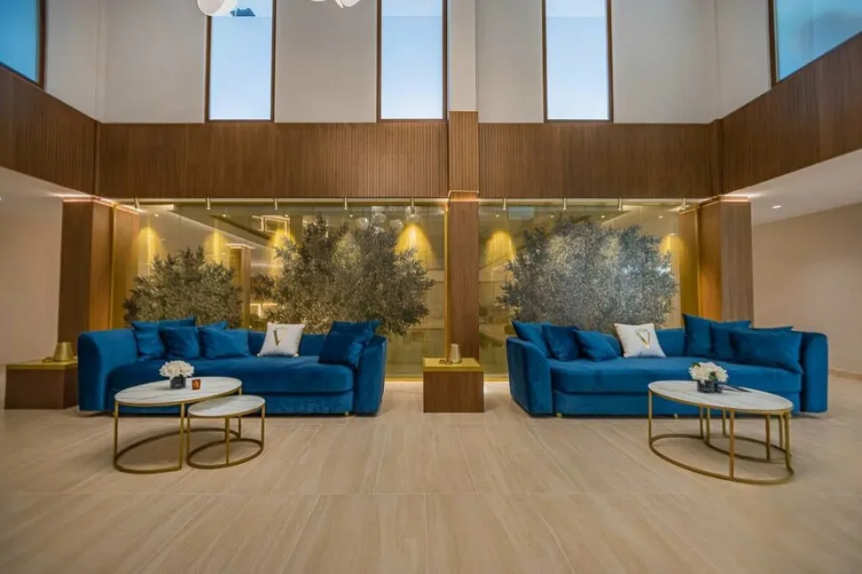 Лобби Onewell Health & Beauty Centre с синими диванами и зелёными растениями