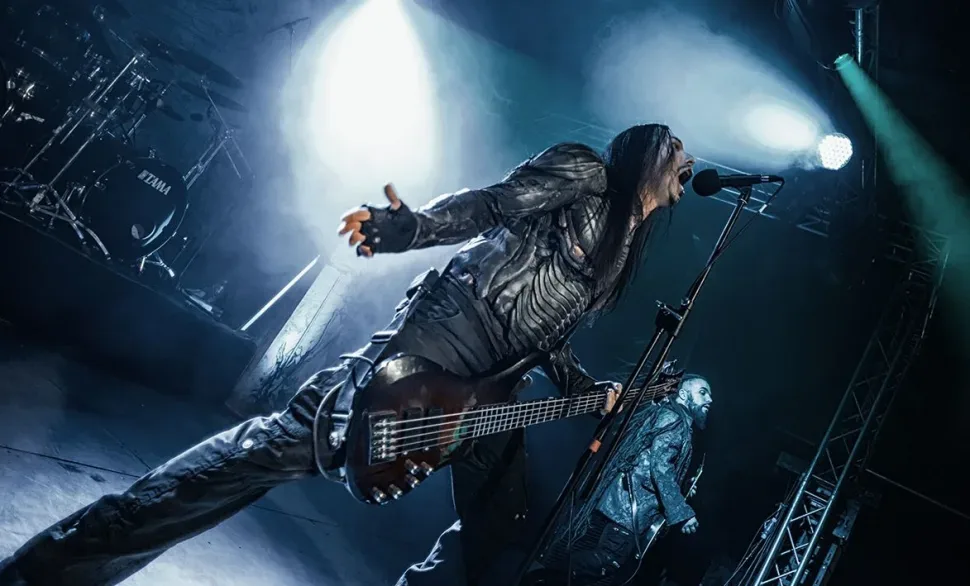 Вокалист Septicflesh выступает в динамичном ракурсе под сцена́рной подсветкой