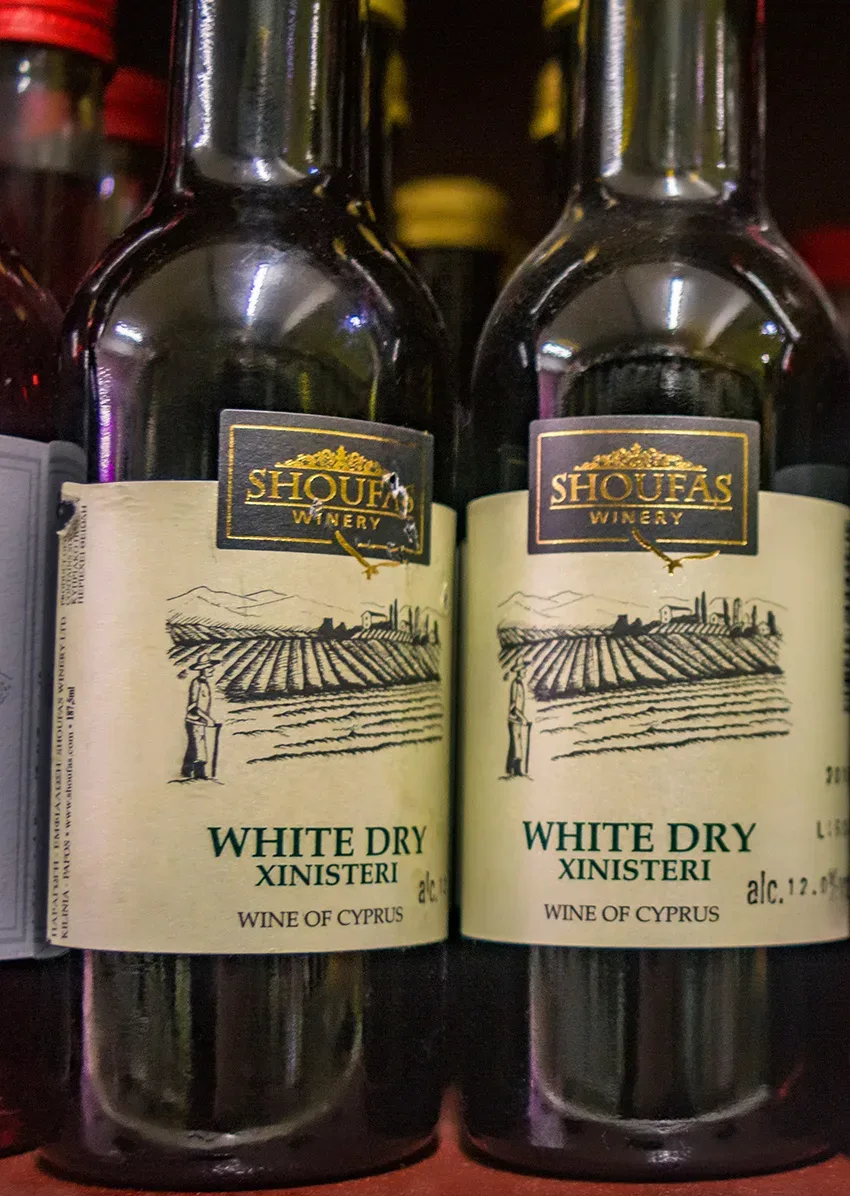 Две бутылки Shoufas White Dry Xynisteri с изображением виноградника на этикетке