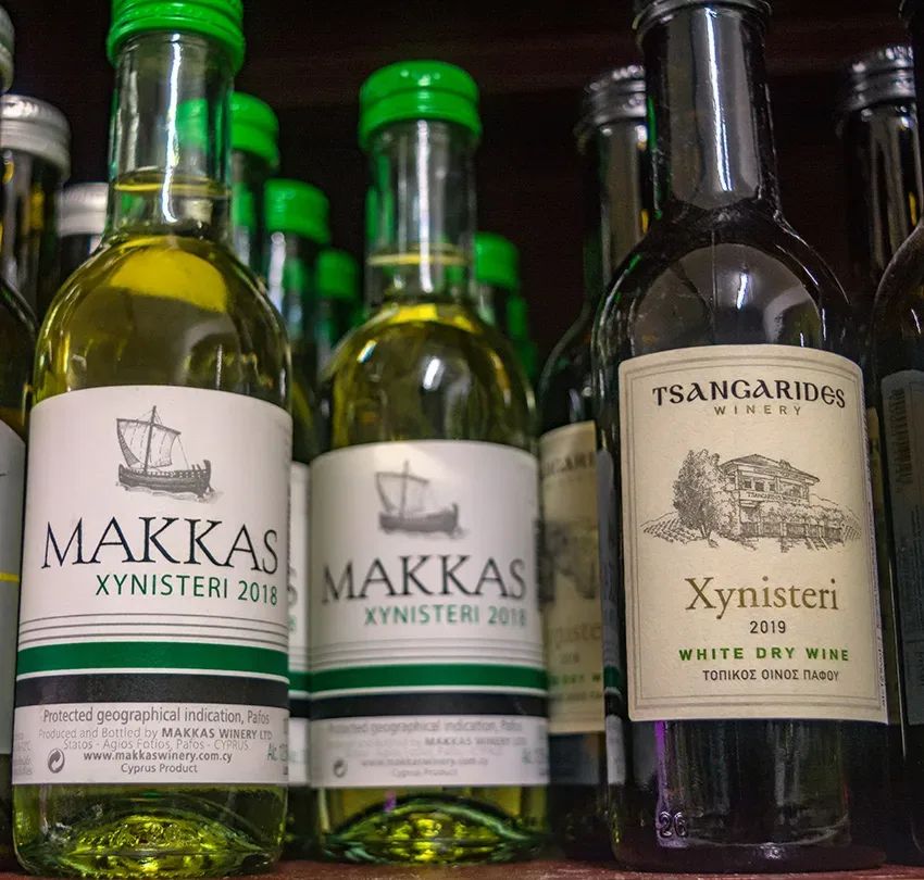 Несколько бутылок вина Makkas Xynisteri на полке супермаркета
