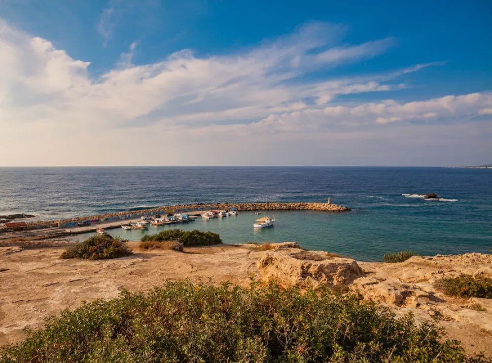 Островок Геронисос на морском горизонте при заходящем солнце
