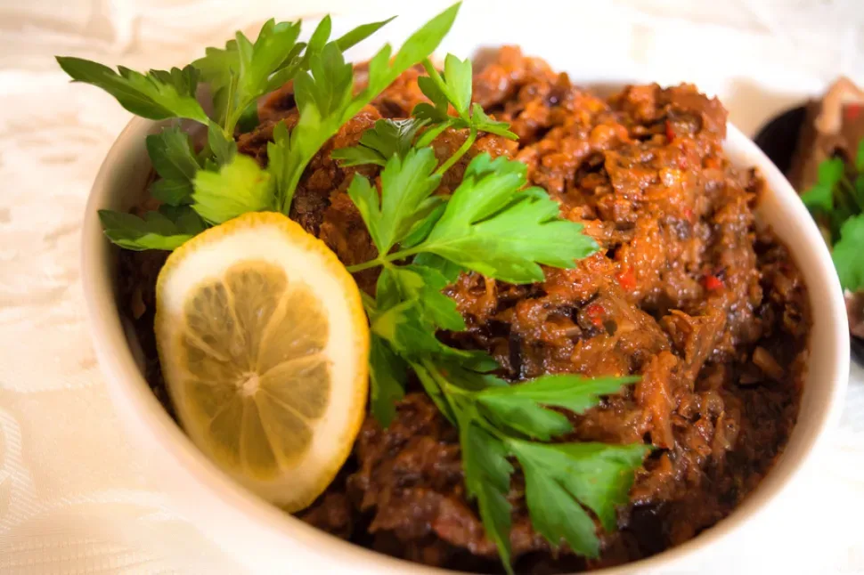 Банка баклажанной икры и кусочек хлеба с намазанной икрой