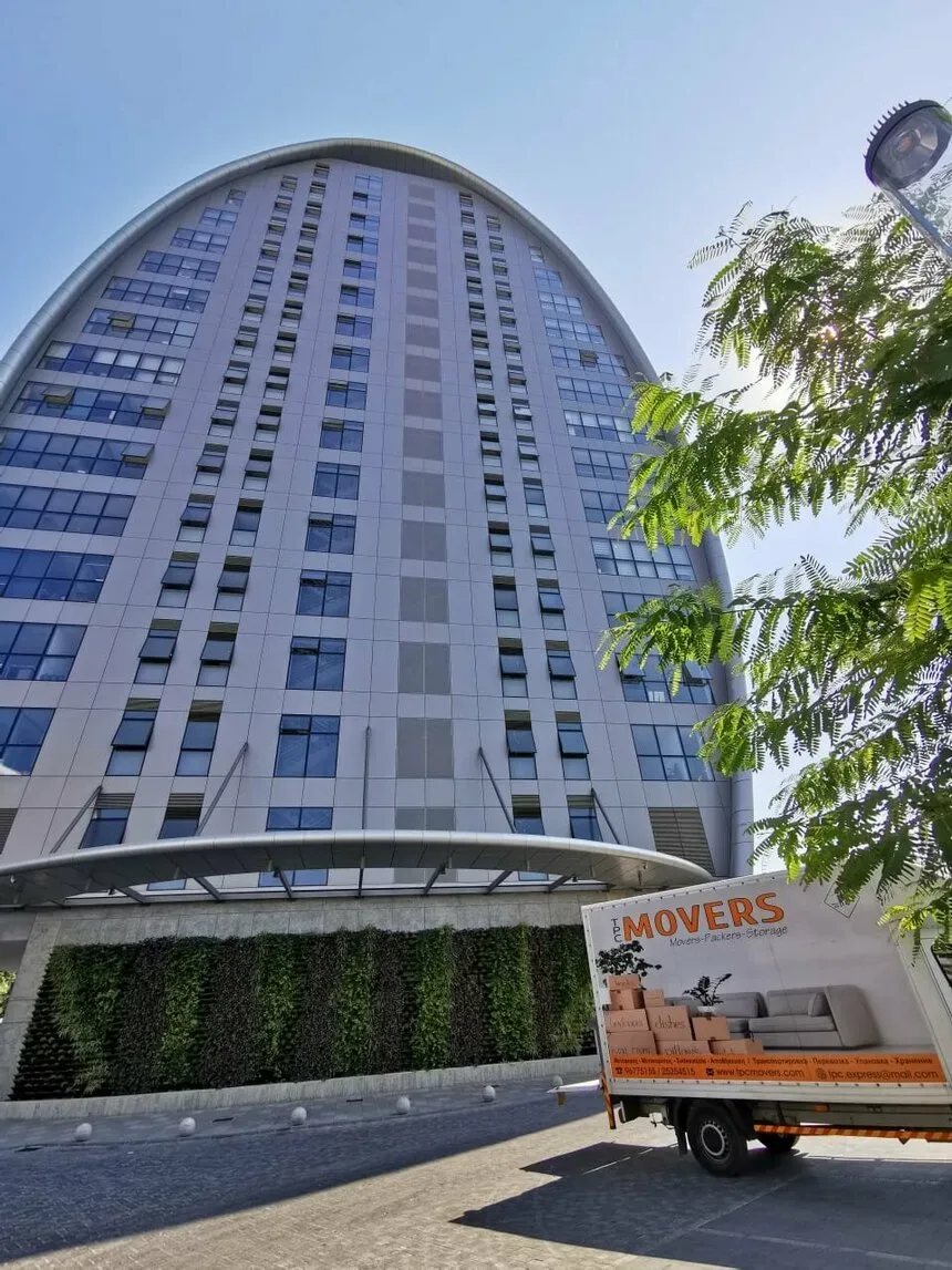 Грузовик TPC MOVERS у современного офисного здания в Лимассоле
