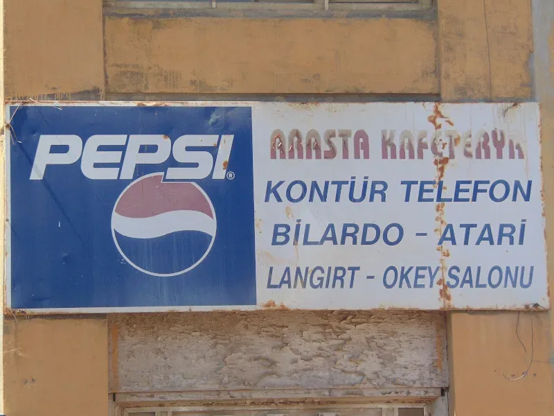 Выцветшая вывеска Pepsi и турецкие надписи на фасаде здания