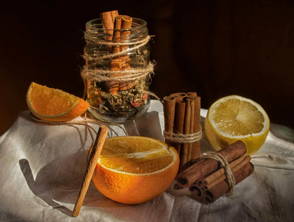 Апельсины, палочки корицы и баночка специй для приготовления сладкого вина Апельсины, палочки корицы и баночка специй для приготовления сладкого вина