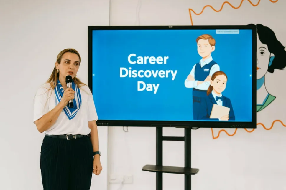 Педагог выступает рядом с экраном с надписью Career Discovery Day Педагог выступает рядом с экраном с надписью Career Discovery Day