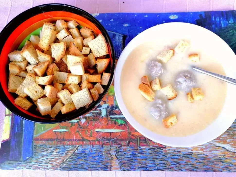 Миска с сухариками и тарелка супа с фрикадельками юварлакья