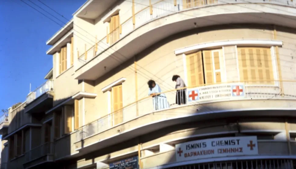 Угловое здание с аптекой и женщинами на балконе