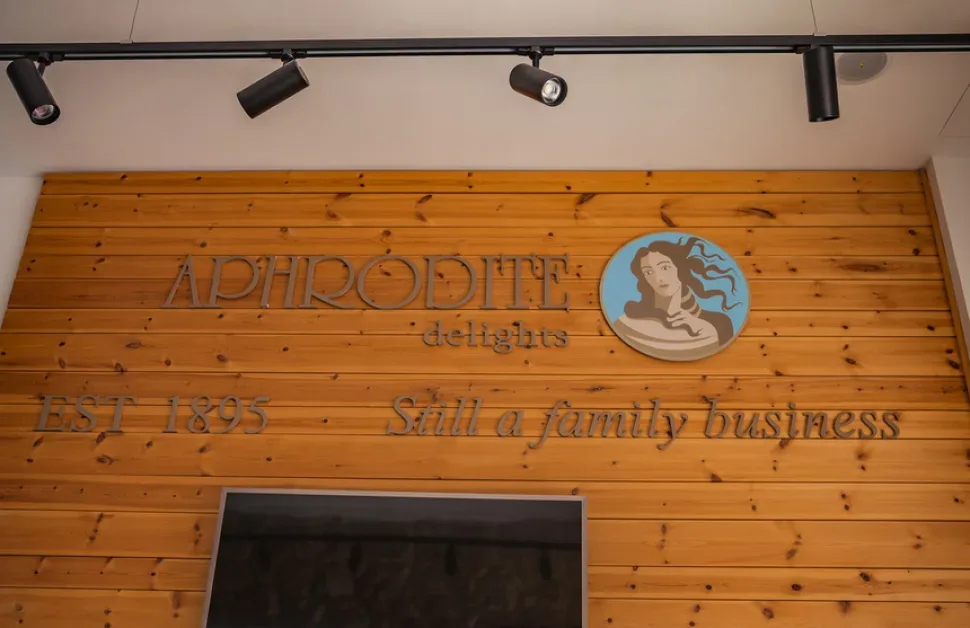 Деревянная вывеска магазина Aphrodite delights над входом Деревянная вывеска магазина Aphrodite delights над входом