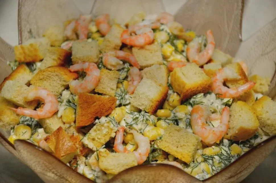 Салат с креветками, кукурузой, укропом и сухариками в миске