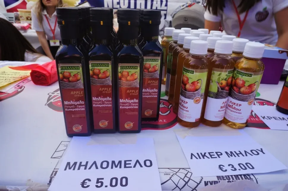 Бутылки с яблочным сиропом и уксусом на прилавке фестиваля