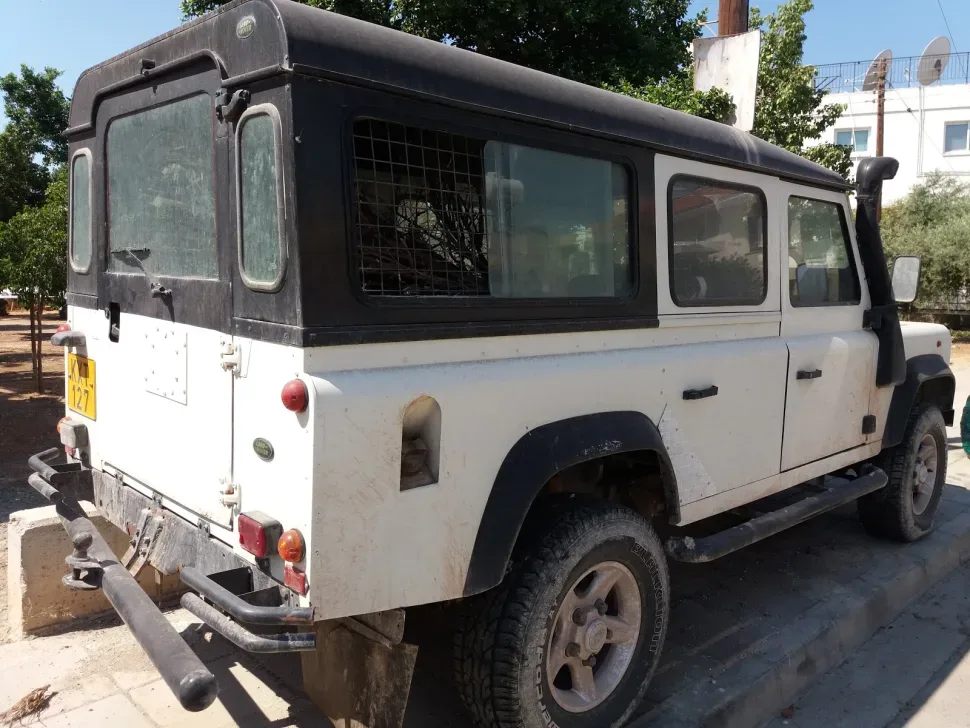 Белый Land Rover Defender длинной колесной базы с высоким багажником