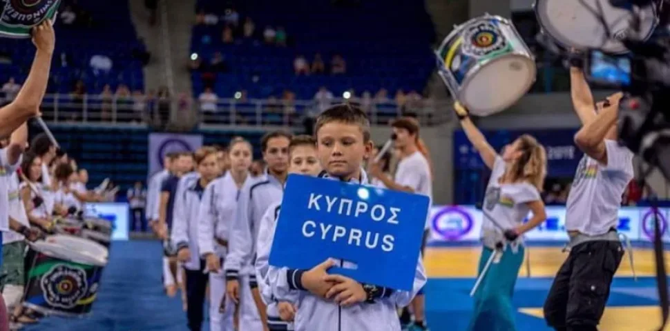 Юниор с табличкой «Кипрос Cyprus» во время парада команд на арене
