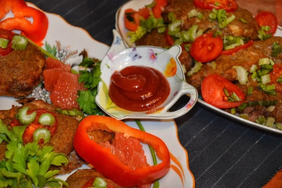 Подача курицы с соусом и ломтиками болгарского перца на блюде
