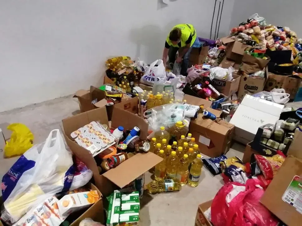 Упакованные коробки и продукты на столе волонтёрского центра перед сортировкой Упакованные коробки и продукты на столе волонтёрского центра перед сортировкой