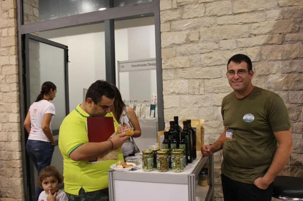 Обсуждение продукции на стенде с оливками и закусками