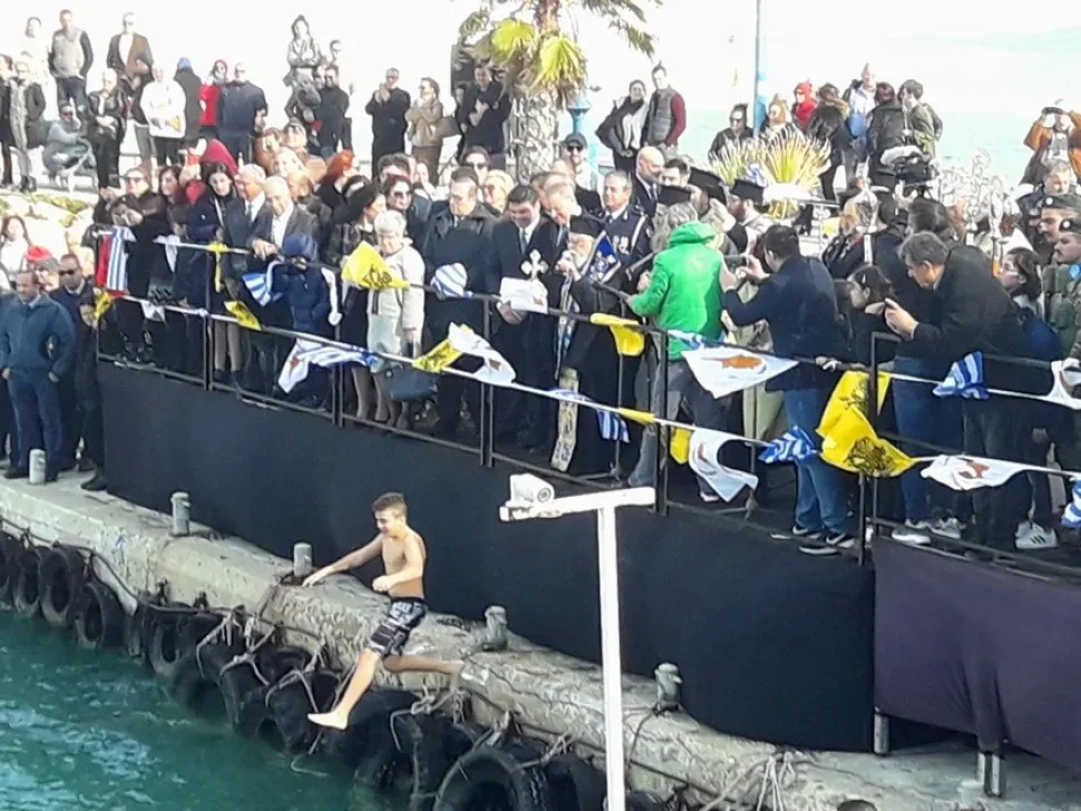Группа пловцов в море держит найденное распятие и крест