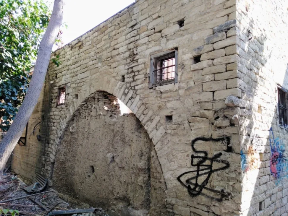 Наружная стена и арочное окно конюшни Пилавакисов во дворе