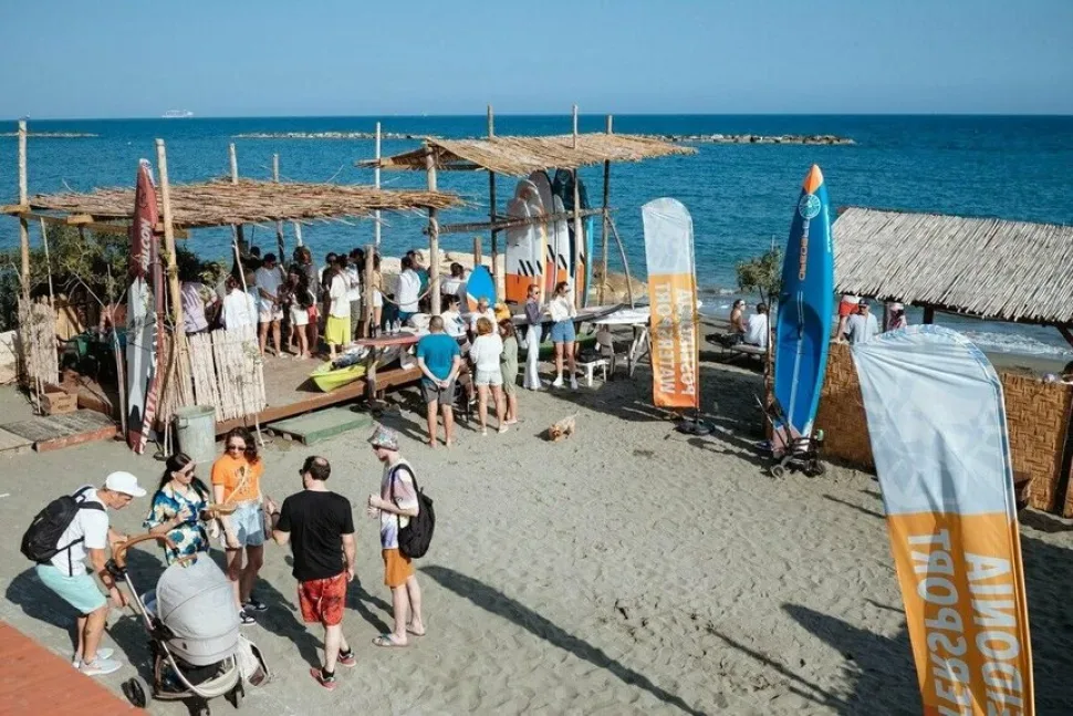 Пляж Poseidonia Watersport сверху с флагами, стойками и группой гостей Пляж Poseidonia Watersport сверху с флагами, стойками и группой гостей