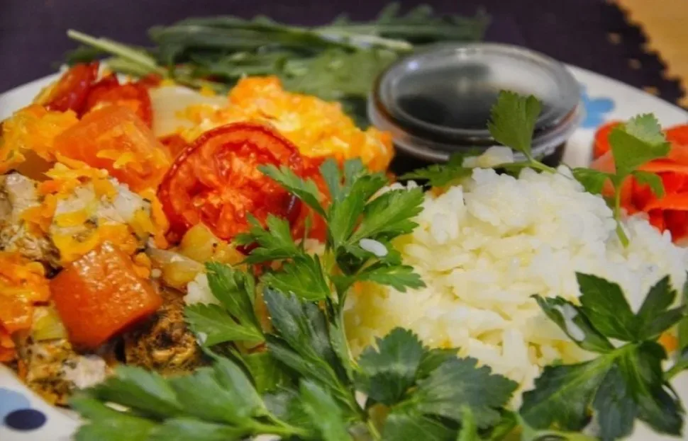 Мясное блюдо с рисом, овощами и зеленью на глубокой тарелке Мясное блюдо с рисом, овощами и зеленью на глубокой тарелке