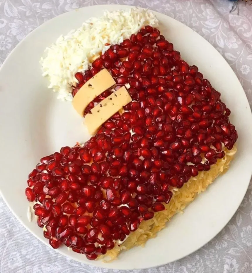 Новогодний салат в виде ёлочки, обсыпанный нарезанным укропом и майонезной сеткой