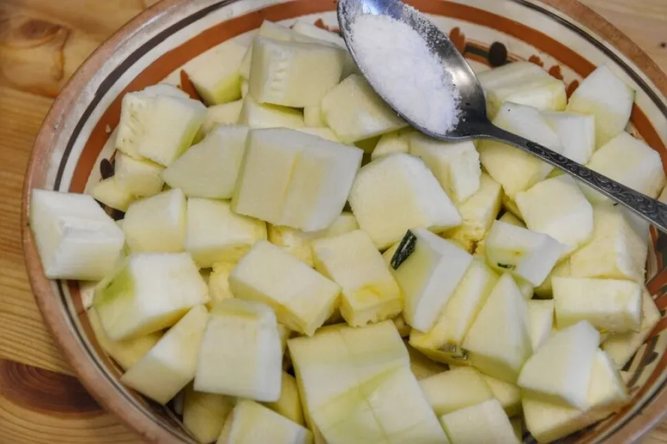Нарезанные кубиками цукини на деревянной разделочной доске