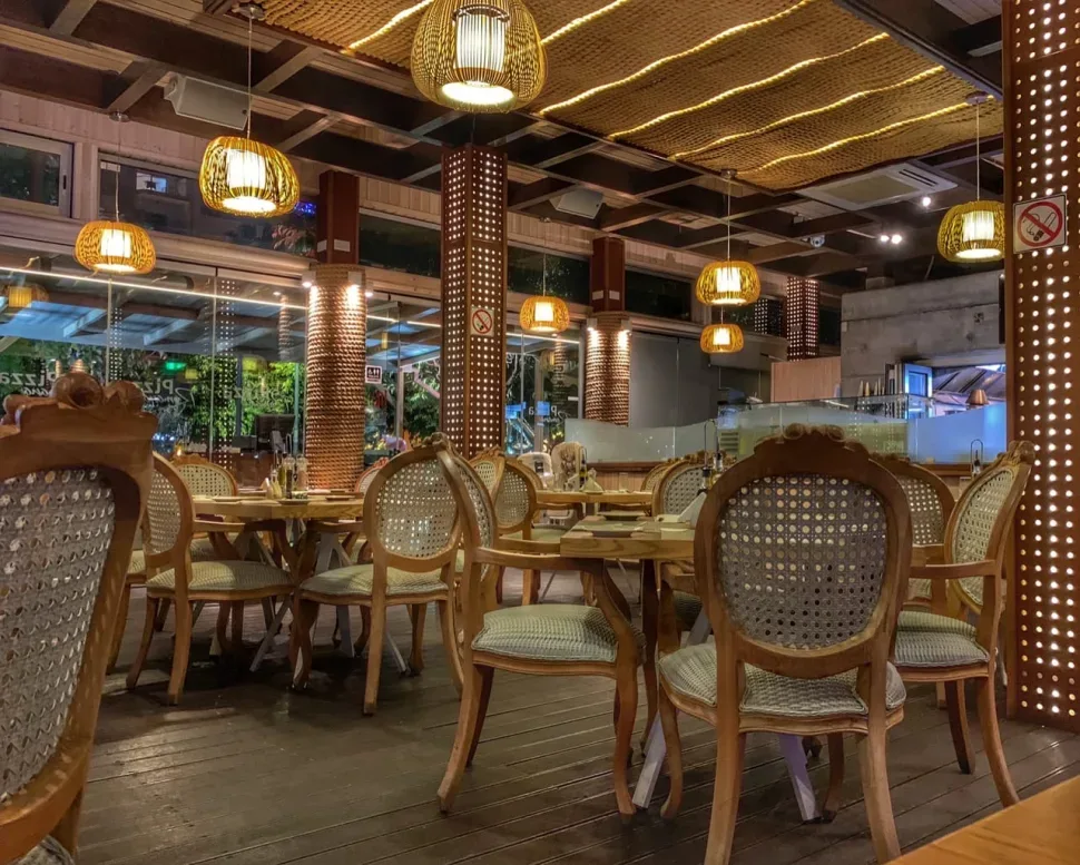 Уютный интерьер Red Cafe с деревянными столами и плетёными стульями