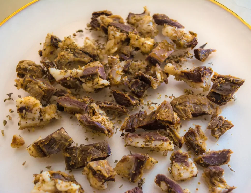 Кусочки сушёной цамареллы, заметна прослойка жира и орегано