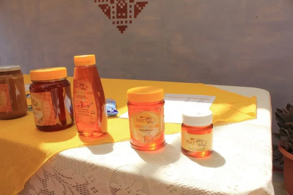 Прилавок с баночками мёда, кремами и визиткой производителя Bee Kind