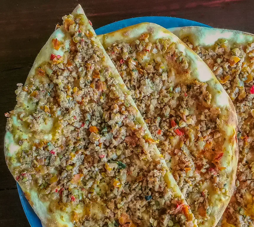 Длинные тонкие куски лахмаджуна, свернутые наполовину на блюде