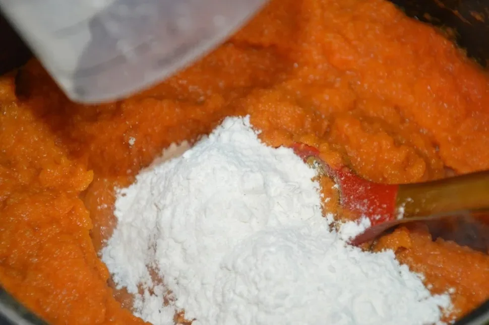 Мерный стакан с мукой для добавления в морковное пюре