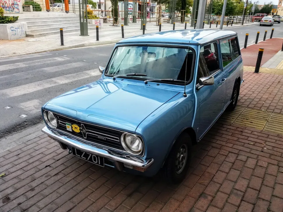 Голубой классический Mini Traveller припаркованный на городской тротуарной плитке