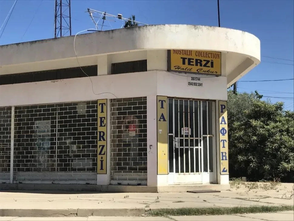Магазин с вывеской TERZI и металлическими решётками на витрине