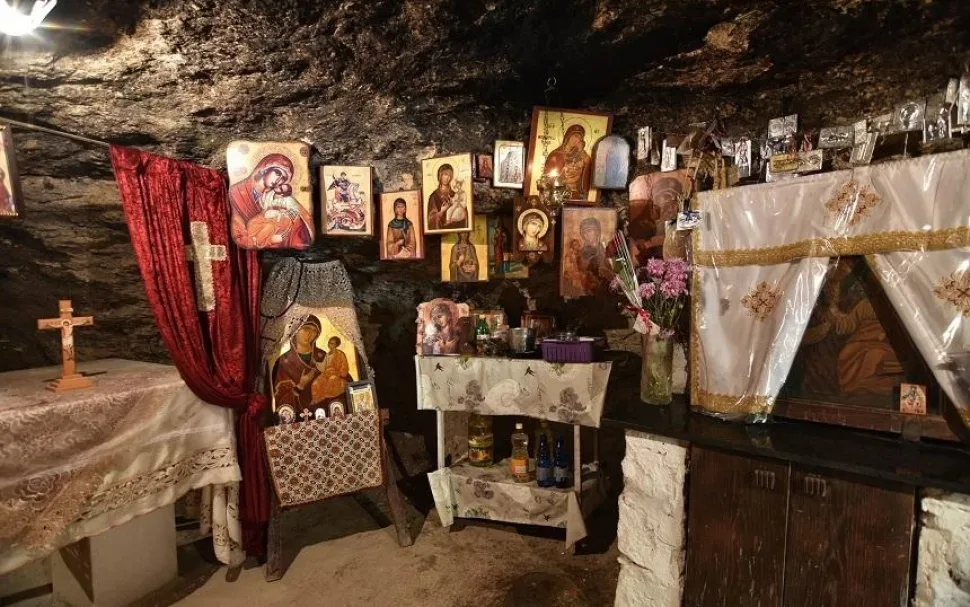 Вход на территорию часовни Панагия Вунаркотисса с аркой и крестом над воротами Вход на территорию часовни Панагия Вунаркотисса с аркой и крестом над воротами
