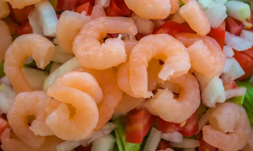 Кипрский салат-коктейль с креветками и овощами на тарелке