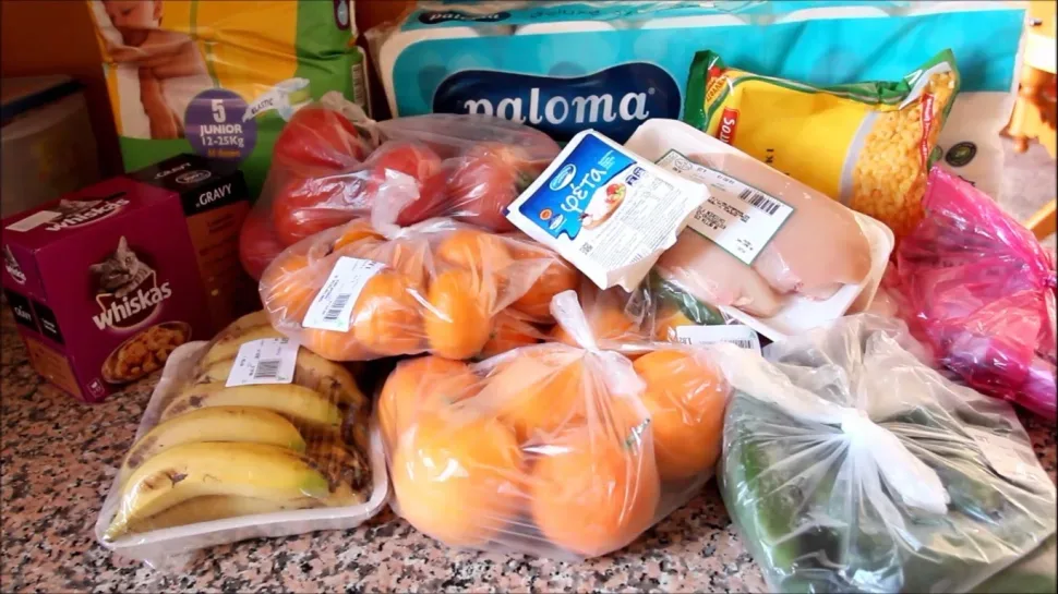Покупки на кухонном столе: фрукты, овощи и упакованное мясо