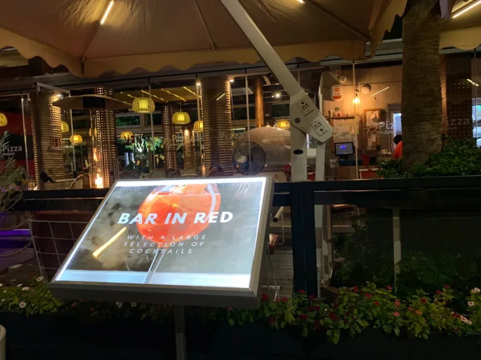 Вывеска и терраса Red Cafe на набережной Молос в Лимассоле