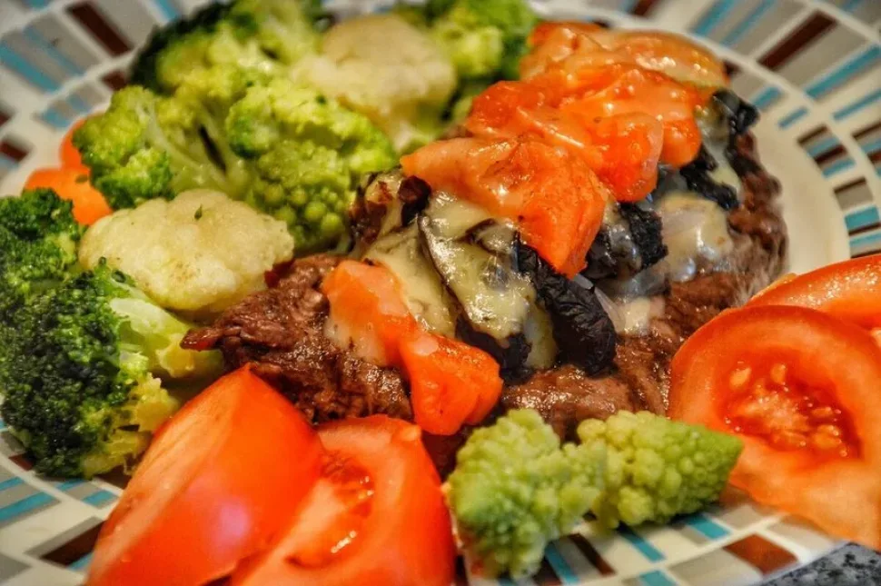 Крупный план отбивной с курагой, черносливом и овощным гарниром
