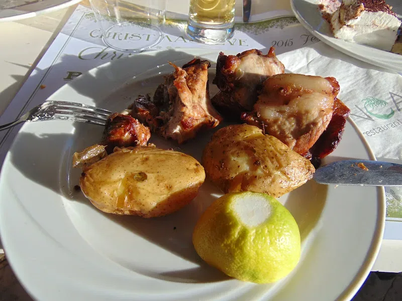 Тарелка с жареным мясом, запечённым картофелем и половинкой лимона