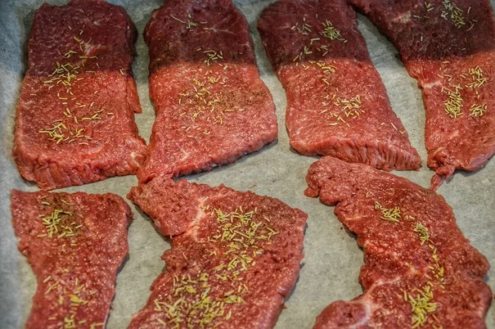 Нарезанный чернослив на доске рядом с помидорами и чесноком