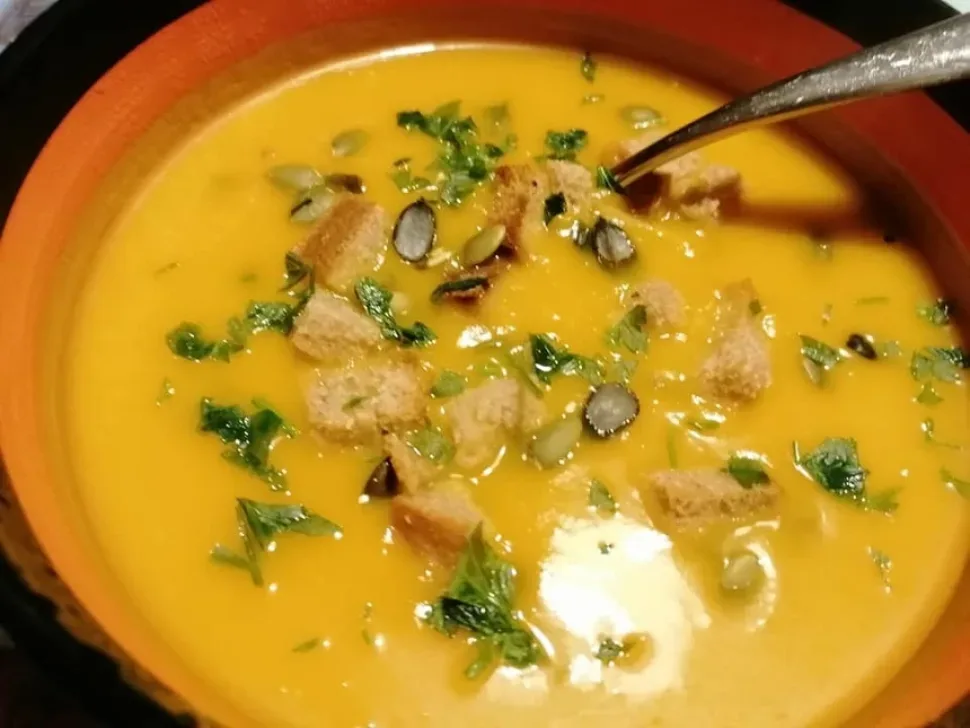 Порция тыквенного супа с гренкой, запечённой с пармезаном и хрустящими кусочками Порция тыквенного супа с гренкой, запечённой с пармезаном и хрустящими кусочками