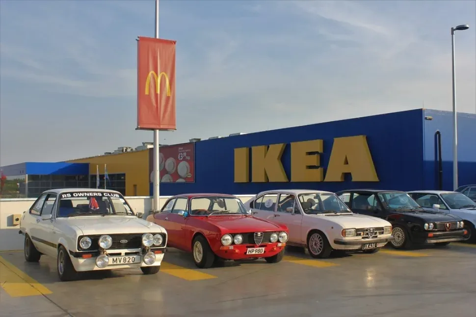 Ряд винтажных европейских автомобилей на фоне вывески IKEA