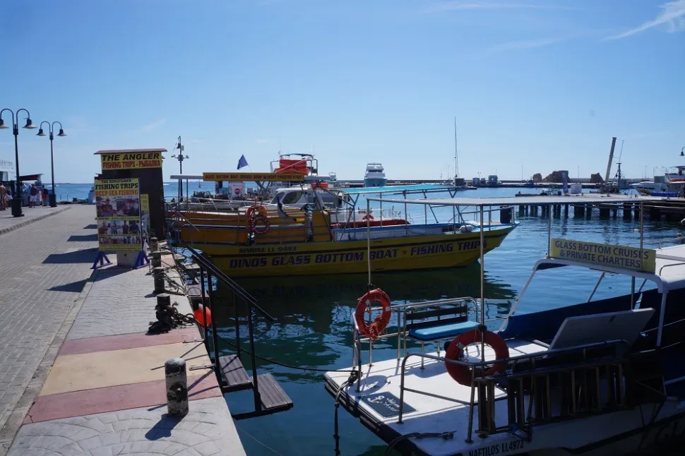Причал с прогулочными лодками и рекламой морских экскурсий в Пафосе