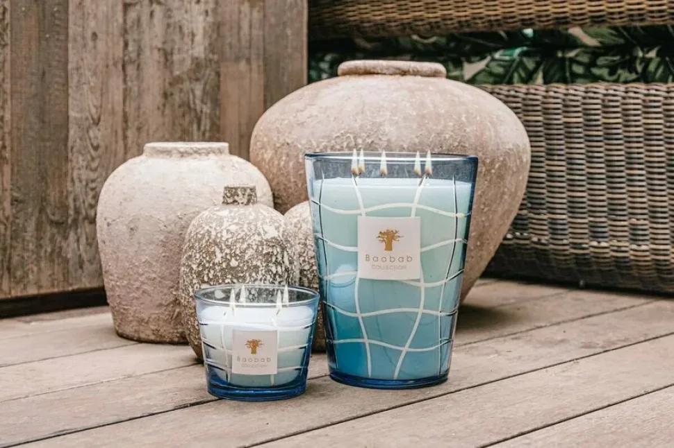 Ароматические свечи Baobab Collection на деревянной поверхности рядом с керамикой