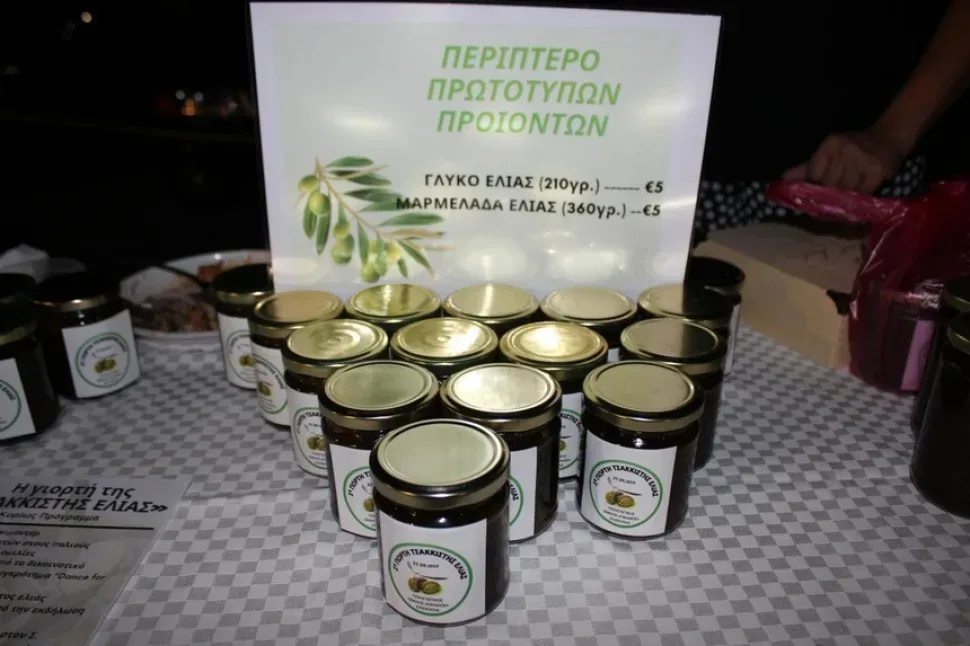 Несколько бутылок тёмного оливкового масла на клетчатой скатерти Несколько бутылок тёмного оливкового масла на клетчатой скатерти