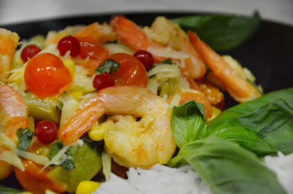 Порция королевских креветок с овощами и рисом как готовое блюдо
