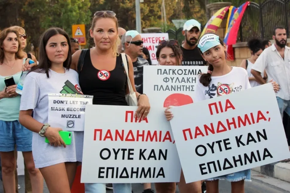 Участники акции у ограды с развевающимися национальными флагами разных стран