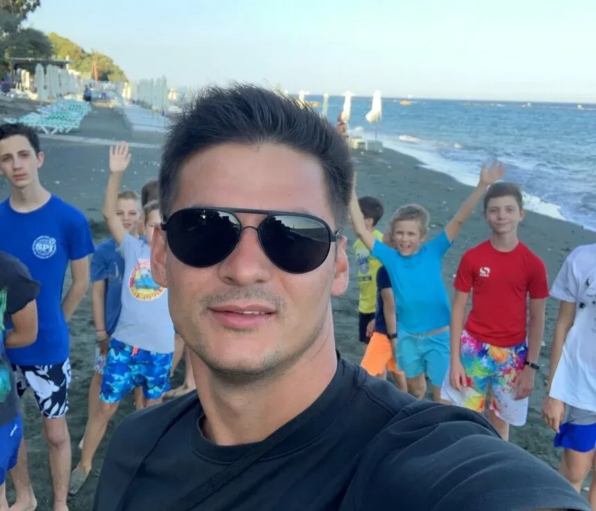 Селфи тренера с группой детей на пляже во время лагеря